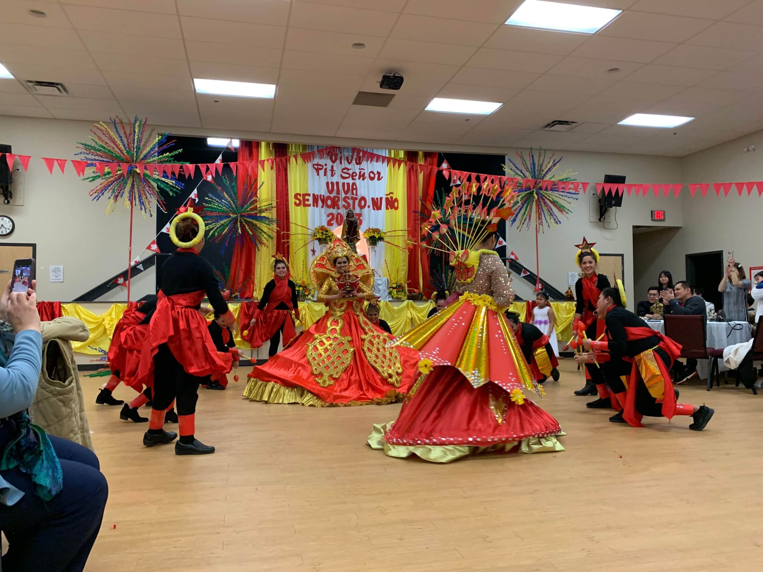 A group of dancers with a statue at a Sinulog festival held in a Catholic church in Fort St. John.
