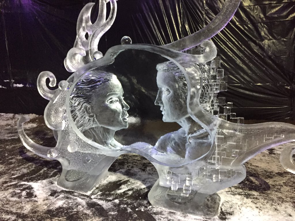 An ice sculpture by Ross and Tony Baisas of a man and women's heads facing one another.