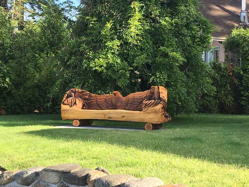 A sofa carved out of wood with an eagle as the back.