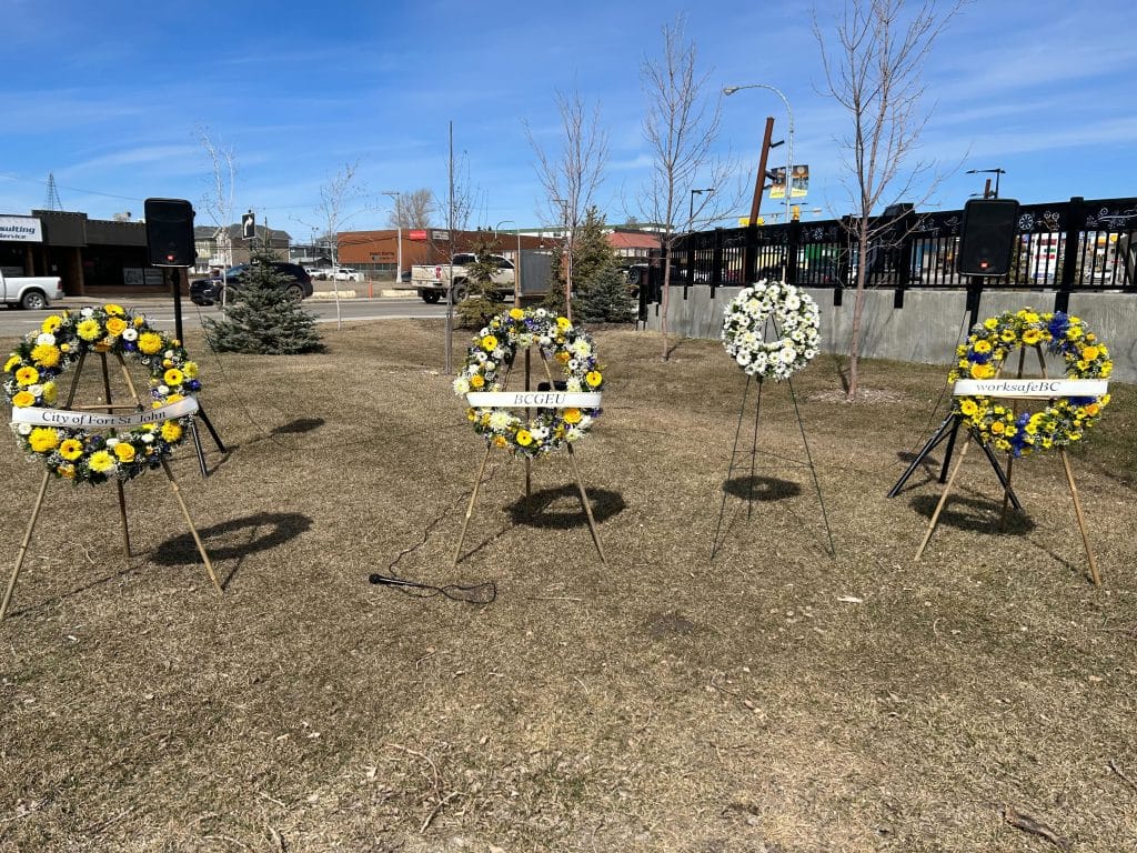 A picture of fourth wreaths on stands in a park. 