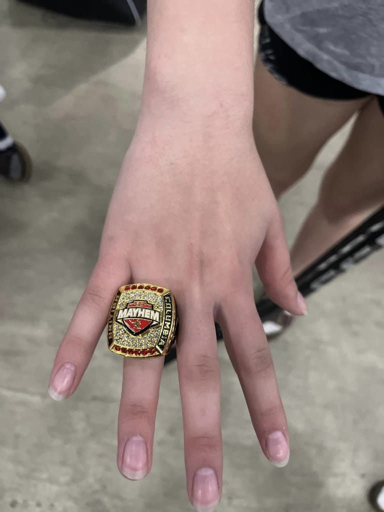 A large British Columbia Mayhem gold ring on a girls hand.