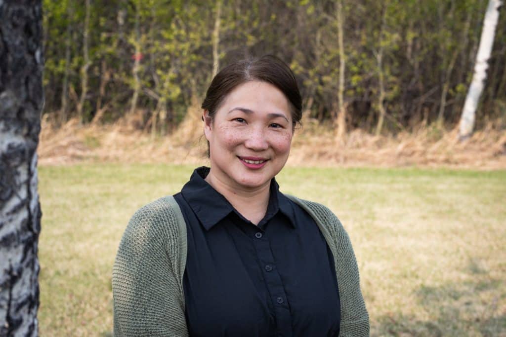 A picture of a smiling woman in a field.