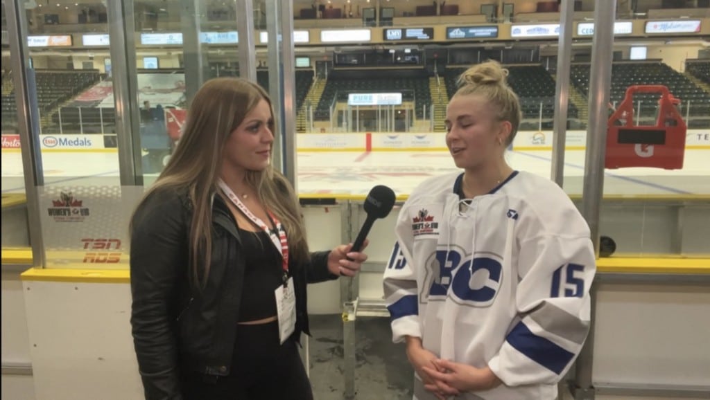 A person interviewing someone in hockey gear